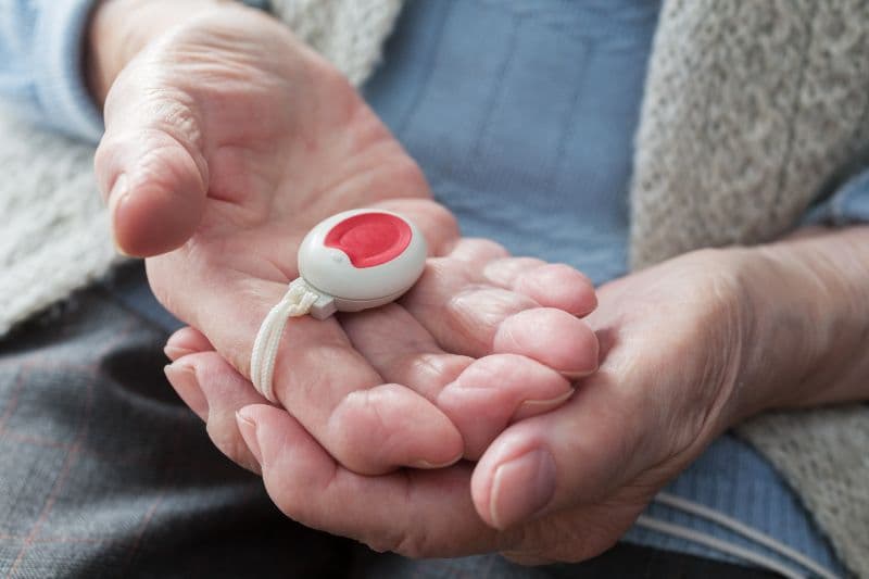 Elderly woman with a medical alert button.