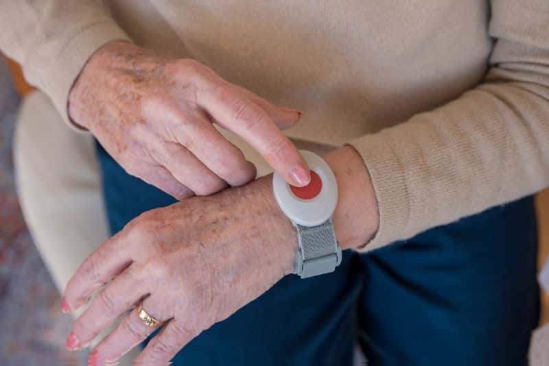 An elderly person wearing a monitored panic button